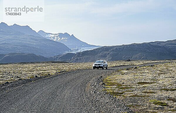 Auto fährt auf Schotterstraße  bergige Landschaft  Island  Europa