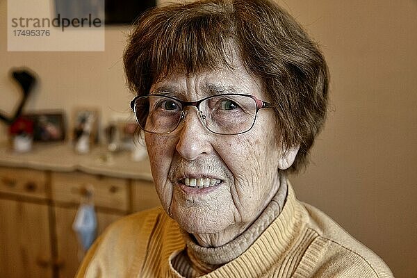 Portrait einer Seniorin zuhause im Wohnzimmer  Köln  Nordrhein-Westfalen  Deutschland  Europa