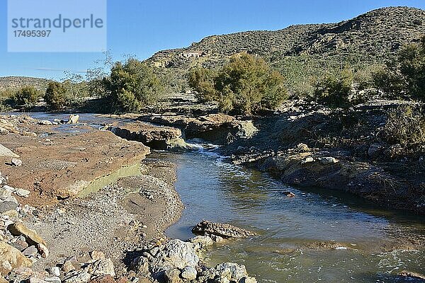 Bach mit felsigem Ufer fließt durch mediterrane Landschaft. Wasserlauf in karger Gegend  Andalusien  Spanien  Europa