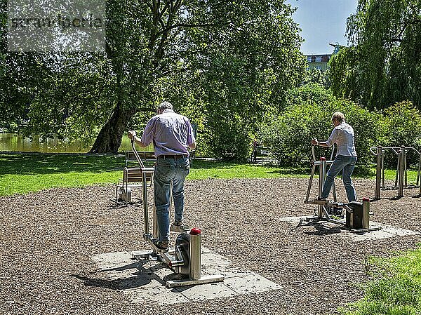 Senioren trainieren an Fitnessgeräten im Freien am Lietzensee Park  Berlin  Deutschland  Europa