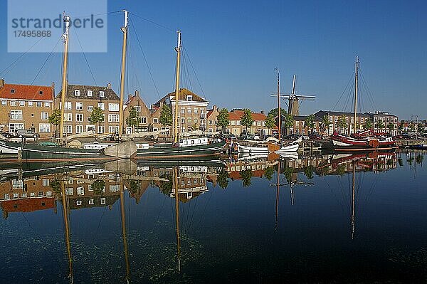 Alte Schiffe und Häuser spiegeln sich im Hafenbecken  Hellevoetsluis  Südholland  Niederlande  Europa