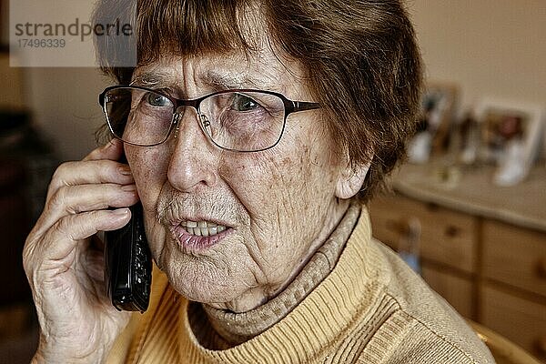 Seniorin zuhause beim Telefonieren schaut unsicher  Enkeltrick  Köln  Nordrhein-Westfalen  Deutschland  Europa