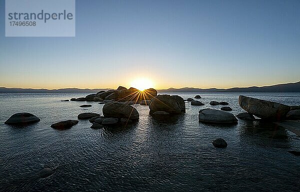 Sonnenuntergang mit Sonnenstern  Runde Steine im Wasser  Ufer am See Lake Tahoe  Sand Harbor State Park  Ufer  Kalifornien  USA  Nordamerika