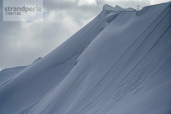 Gipfelkreuz der Höferspitze mit überwechtetem Gipfelgrat und Bergsteigern  Baad  Kleinwalsertal  Vorarlberg  Österreich  Europa