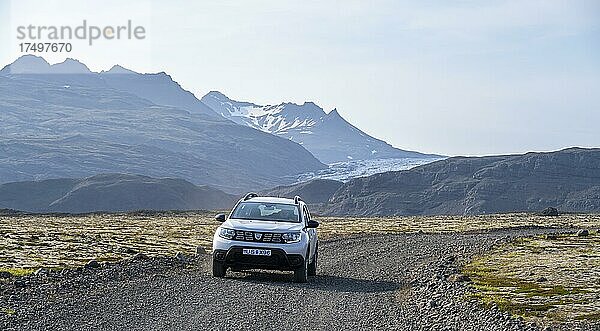 Auto fährt auf Schotterstraße  bergige Landschaft  Island  Europa