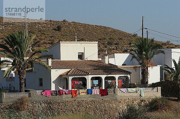 Haus mit Palme und vielen bunten Tüchern beim Trocknen  Andalusien  Spanien  Europa
