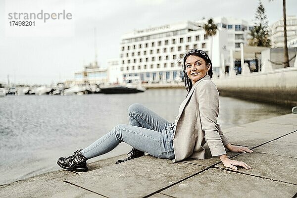 Junge Frau sitzt am Yachthafen in Faro  Algarve  Portugal  Europa