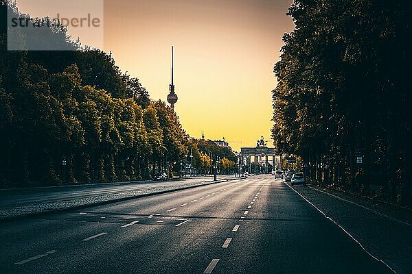Leere Straße des 17. Juni im Morgenrot mit Brandenburger Tor und Berliner Fernsehturm  Berlin  Deutschland  Europa