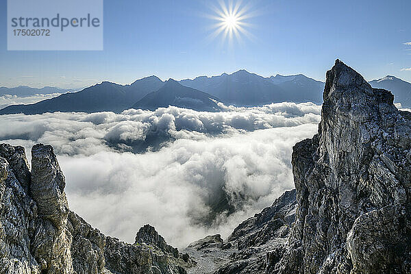 Die Sonne geht über dem dichten Nebel auf  der das Tal in den Ortler-Alpen einhüllt