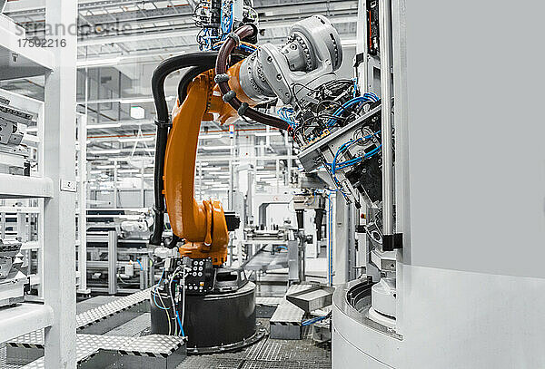 Orangefarbener Roboterarm in automatisierter Fabrik