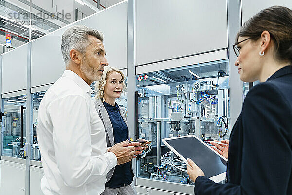 Kollegen diskutieren in einer automatisierten Fabrik