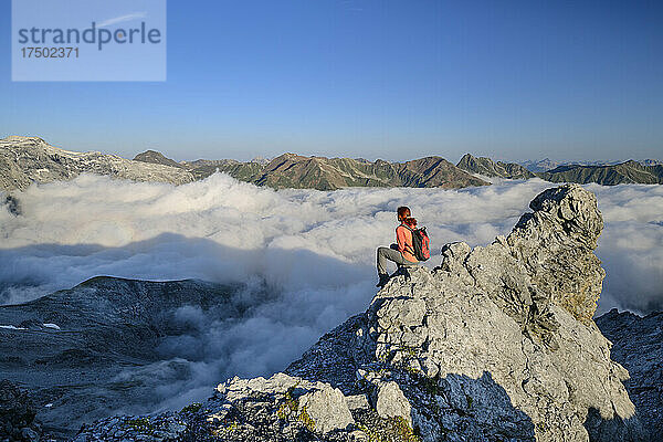 Wanderin mit Blick auf das nebelverhangene Tal in den Ortler-Alpen