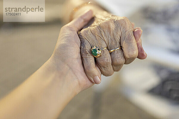 Enkelin und Großmutter halten sich an den Händen