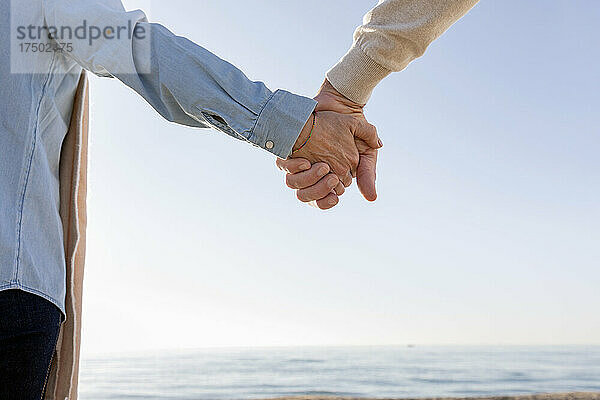Paar hält Händchen am Strand