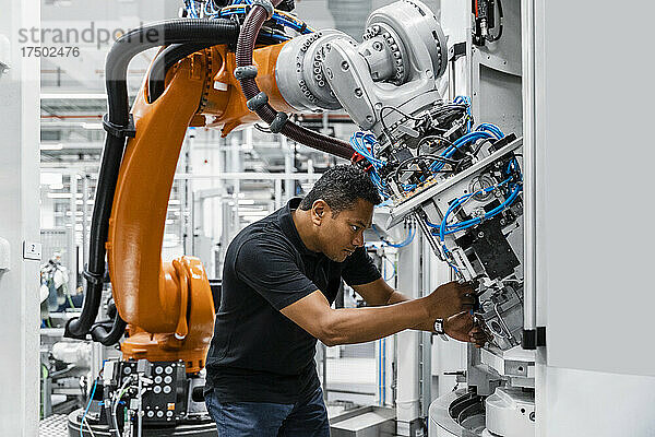 Ingenieur untersucht Roboterarm in Fabrik