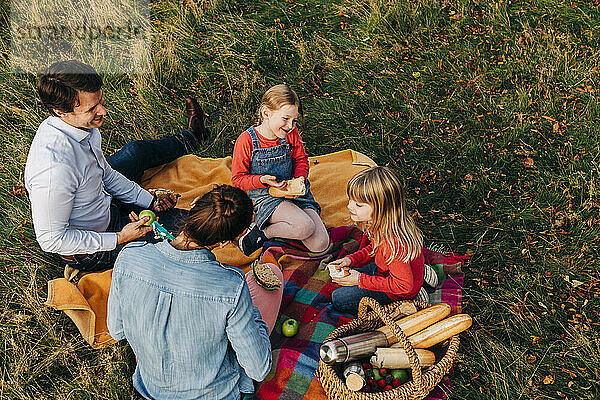 Glückliche Familie beim gemeinsamen Essen beim Picknick