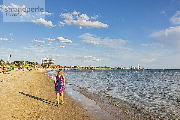 Australien  Victoria  Melbourne  Touristin spaziert im Sommer am Saint Kilda Beach entlang