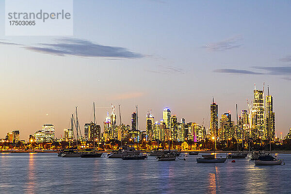 Australien  Victoria  Melbourne  Yachten schweben in der Abenddämmerung vor der beleuchteten Skyline der Stadt