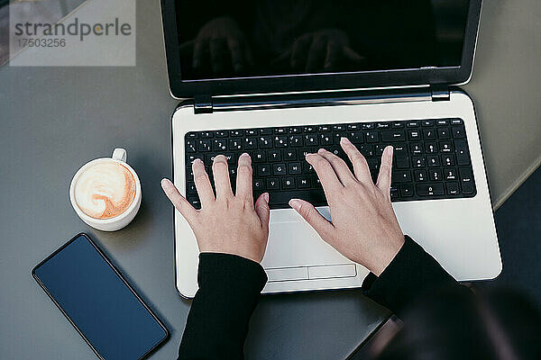 Geschäftsfrau benutzt Laptop am Cafétisch