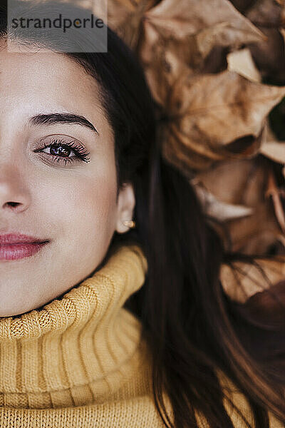 Lächelnde Frau auf trockenen Blättern