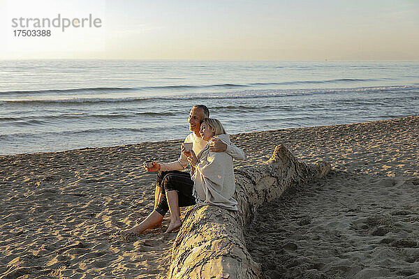 Mann und Frau genießen den Sonnenuntergang am Strand