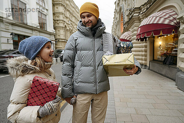 Vater kauft mit Tochter Weihnachtsgeschenke auf der Stadtstraße ein