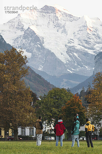 Mann zeigt Freunden den Berg in Iseltwald  Interlaken  Schweiz