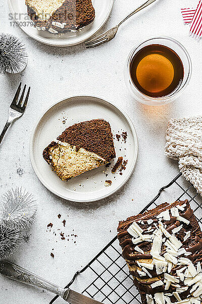 Schokoladen- und Vanillekuchenscheiben auf dem Teller mit Getränk auf dem Tisch