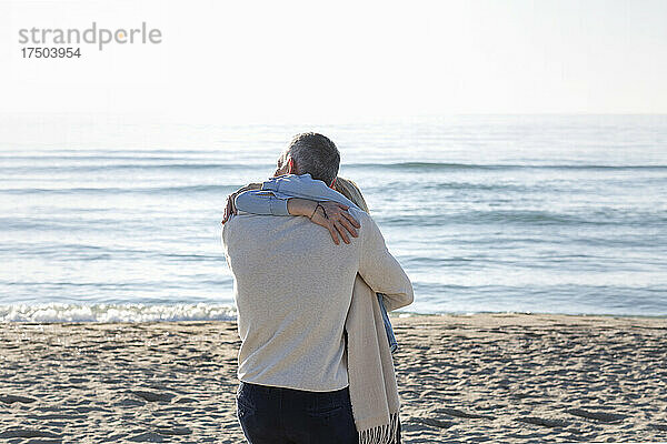 Paar umarmt sich am Strand