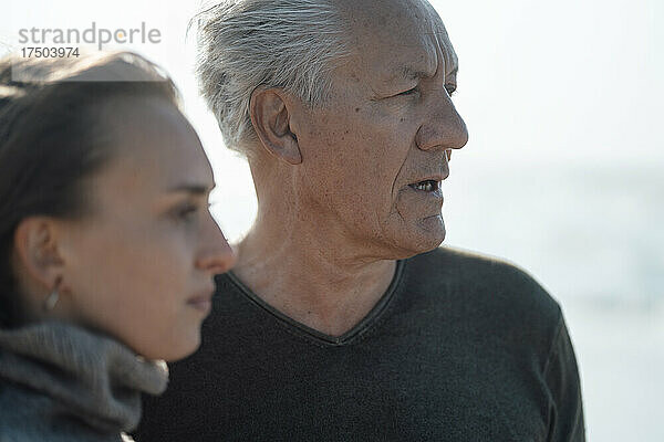 Älterer Mann spricht mit Tochter am Strand