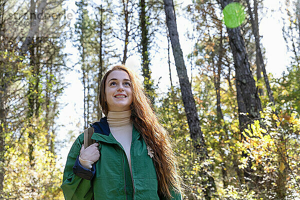 Nachdenkliche Frau schaut beim Wandern im Wald weg