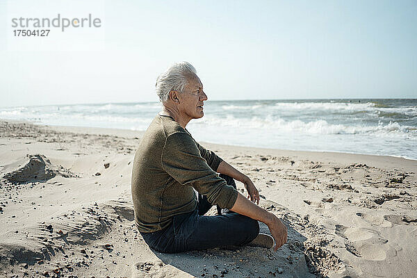 Älterer Mann blickt aufs Meer