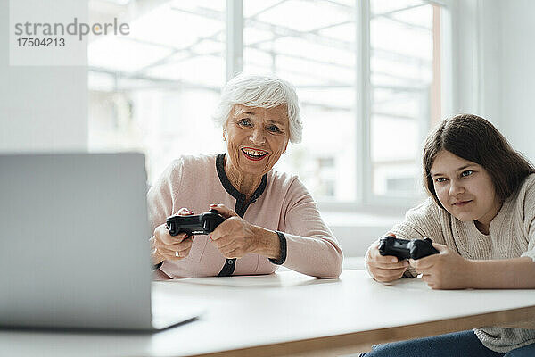 Ältere Frau spielt zu Hause Videospiel mit Mädchen