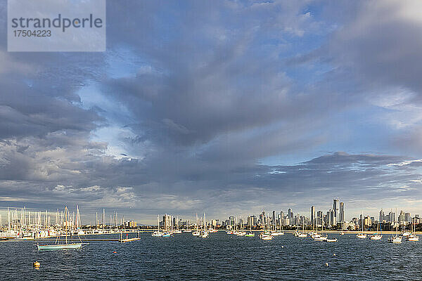 Australien  Victoria  Melbourne  graue Wolken über der Küstenstadt mit schwimmenden Booten im Vordergrund