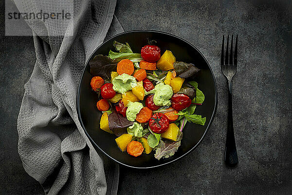 Studioaufnahme einer Schüssel veganen Salats mit gebackenem Gemüse