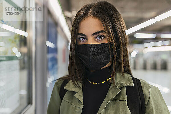 Frau mit schützender Gesichtsmaske in der U-Bahn