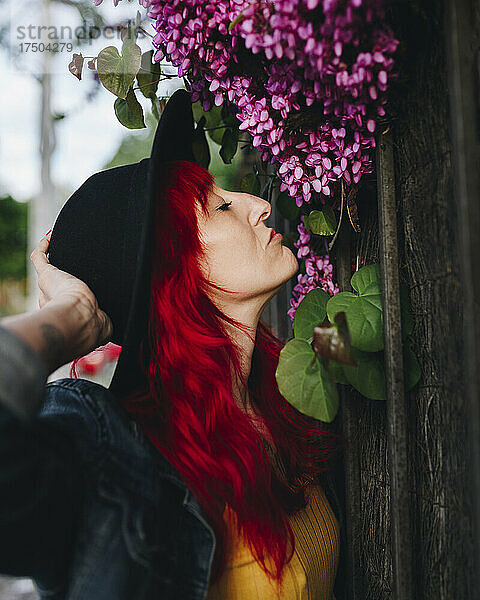 Frau mit roten Haaren duftet nach Blumen