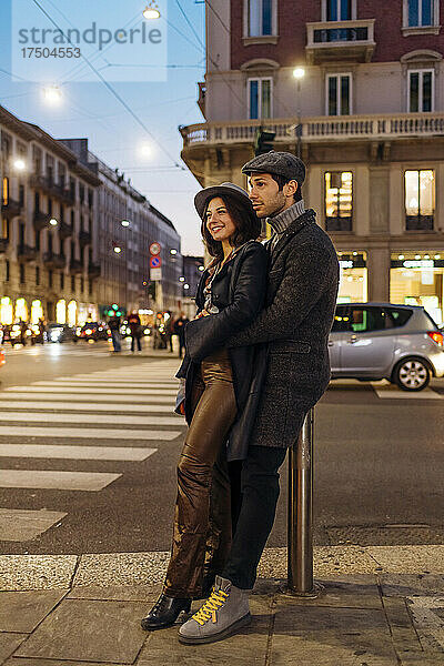 Lächelndes junges Paar  das zusammen auf der Stadtstraße steht