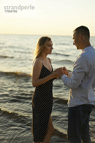 Junges Paar hält Händchen am Strand