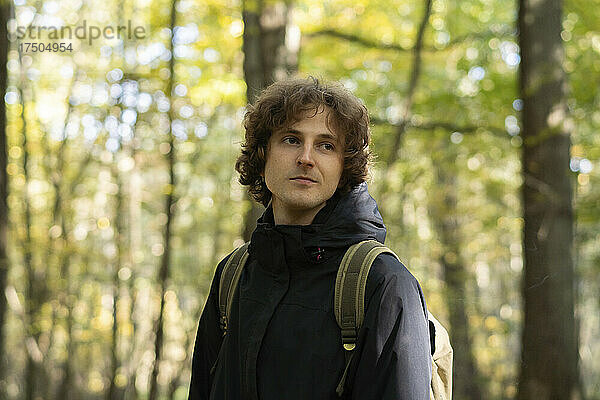 Junger Mann mit Rucksack im Wald