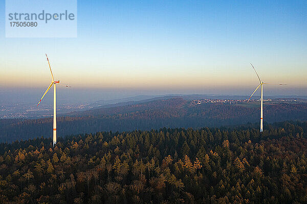 Luftaufnahme eines Windparks im bewaldeten Schurwald-Gebirge in der Abenddämmerung
