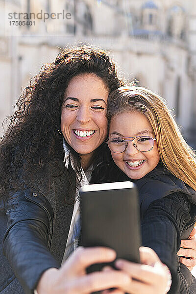 Glückliche Mutter und Tochter machen Selfie mit dem Handy
