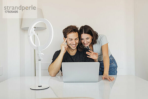 Junges freiberufliches Paar arbeitet gemeinsam am Laptop im Heimbüro