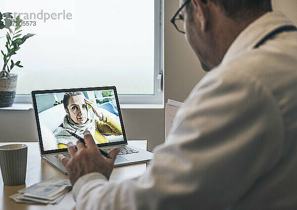 Patient mit Kopfschmerzen spricht per Videoanruf mit dem Arzt in der Klinik