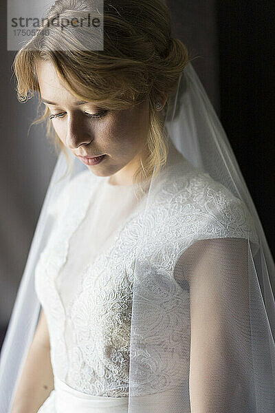 Junge Braut trägt weißes Hochzeitskleid