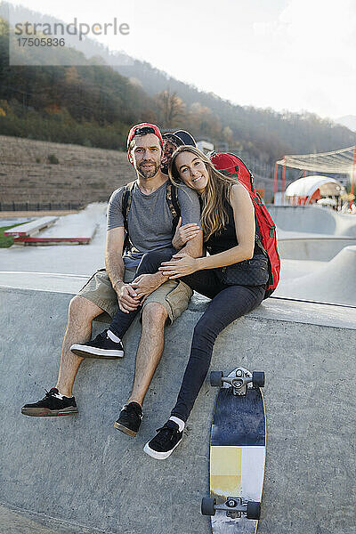 Frau sitzt mit Mann an der Wand im Skatepark
