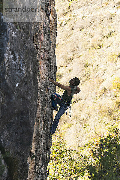Wanderer klettert auf Felsenberg