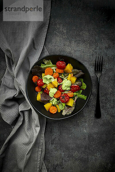 Studioaufnahme einer Schüssel veganen Salats mit gebackenem Gemüse