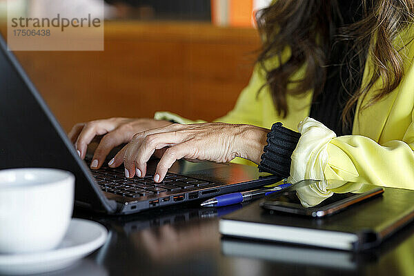 Geschäftsfrau benutzt Laptop am Tisch im Café
