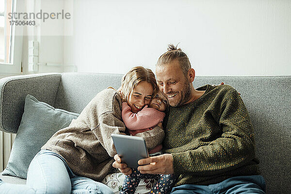 Glückliche Familie  die zu Hause einen Tablet-PC nutzt